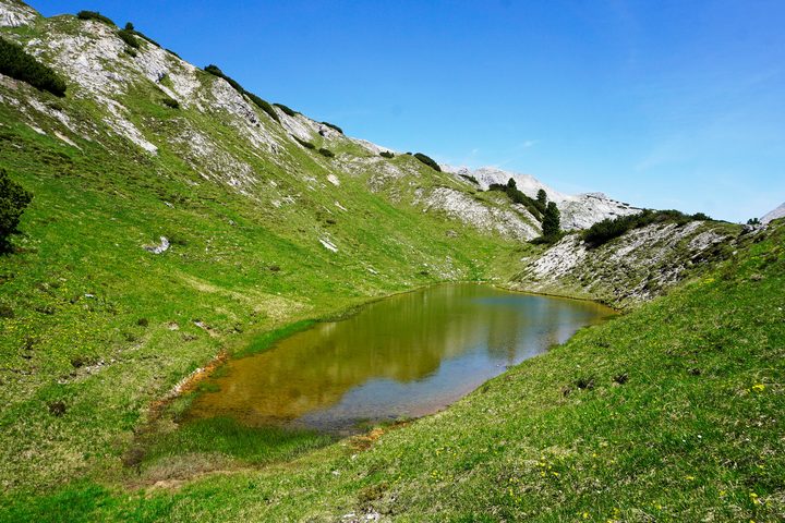 Brunner See in einer offenen Bergmulde.